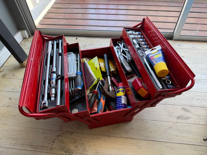 Red metal toolbox filled with tools