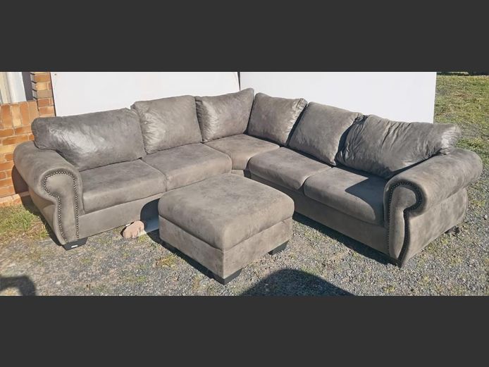 GREY UPHOLSTERED L-SHAPED LOUNGE SUITE WITH MATCHING OTTOMAN, 280 x 280cm [Cigarette burns]