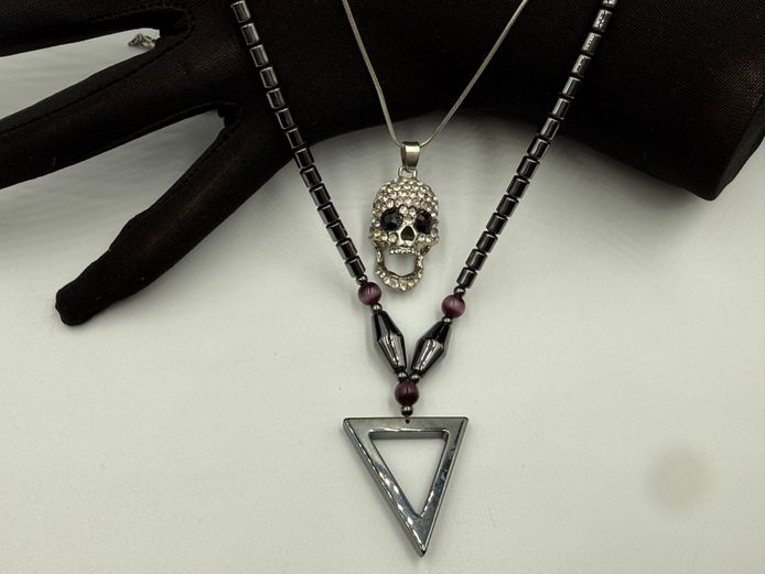 Magnite necklace with triangle pendant and snake necklace with skull pendant
