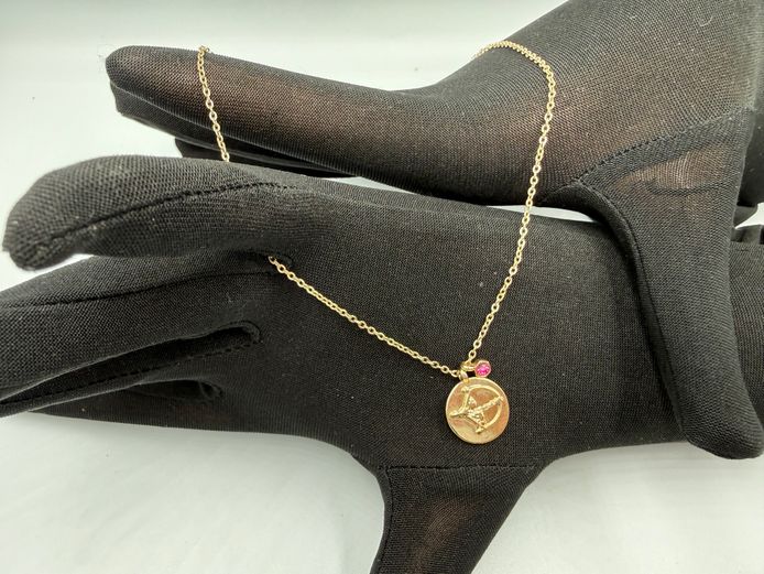 Golden coloured necklace with pink stone and cupid charms