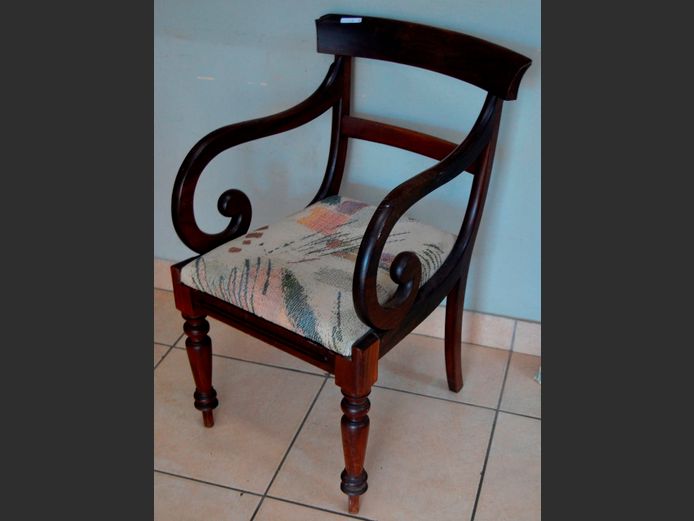 CARVED MAHOGANY SCROLLED ARMCHAIR WITH UPHOLSTERED SEAT [1 corner chipped on back rest]