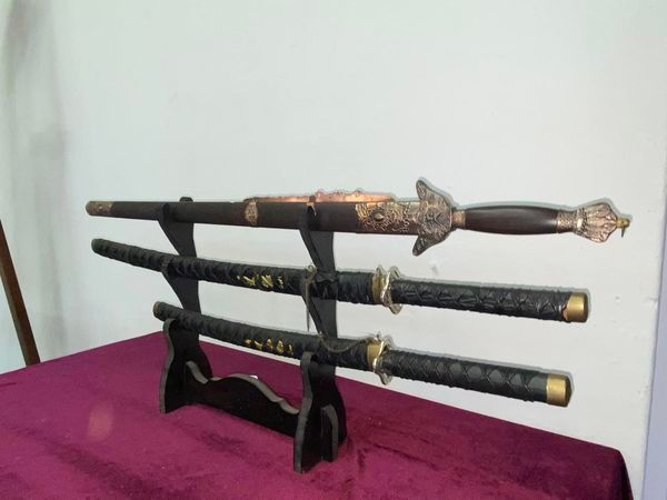 Set of 3 reproduction swords on stand