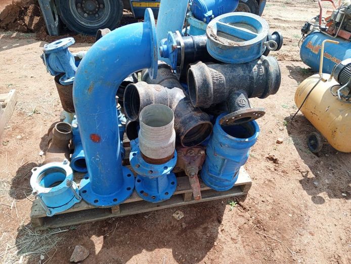 Assorted industrial pipe fittings, including bends, tees, and valves