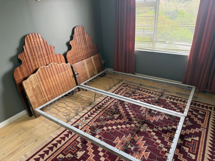 Set of two single steel framed beds with wooden headboards and foot pieces